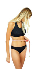 Obraz premium Young attractive woman measuring her hips