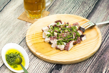 Octopus with paprika and beer, typical dish of Spain, on a woode