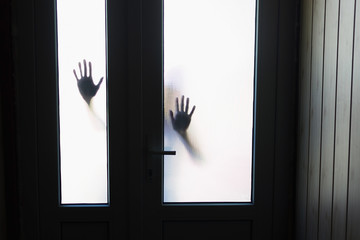 silhouette of hands outside the window