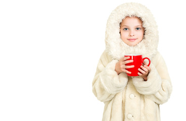 Smiling little girl in winter clothes with a red cup of hot drink