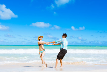 Fototapeta premium Happy young couple playing on the beach. 