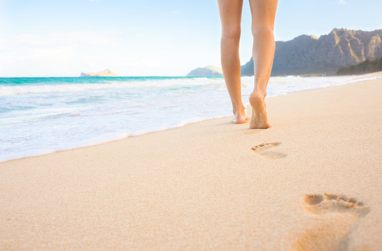 Closeup of woman's feet walking on a beach in Hawaii.