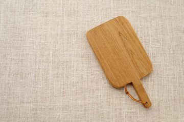 Empty wooden chopping board on sack tablecloth background