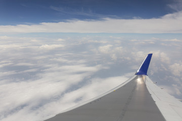 the sky when i am looking through window aircraft during flight in wing with a blue sky.