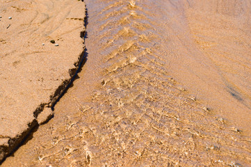 Water flowing over sand forming intricate pattern