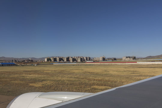 the view  when i am looking through window aircraft during flight to Mongolia  and see Mongolia airport .