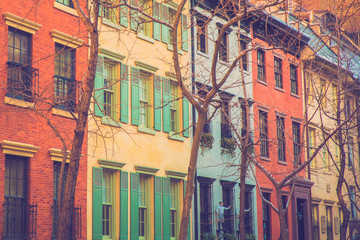 Charming row of colorful apartment building homes on quaint street in New York City with retro filter effect.