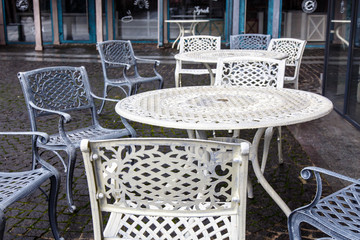 Empty metal tables and chairs in a street cafe in the fall.