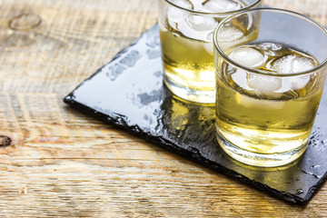 glass of whiskey on wooden background