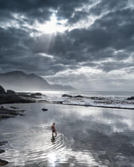 Hermanus, South Africa - Man in tidal pool reflecting the sky at