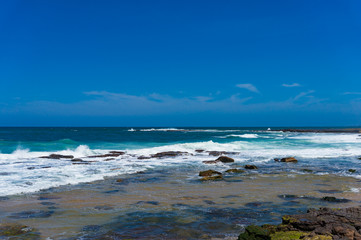Fototapeta na wymiar Blue ocean surface and clear sky. Summertime vacation background