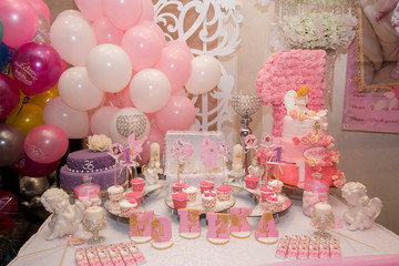 Sweet buffet on a pink table in a happy bersday party.