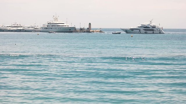 Big white yachts. Boats near lighthouse. Sea travel on luxury yacht.
