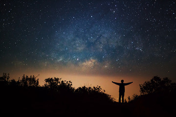 milky way galaxy and silhouette of a standing happy man on Doi L