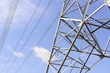Closeup of the base structure of electricity pylon with the blue sky