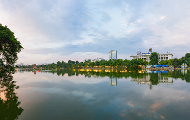 Obraz premium Hoan Kiem lake panorama view at sunset period with ancient Turtle Tower and Hanoi post office (Buu Dien Ha Noi in Vietnamese) . Hoan Kiem lake (Sword lake or Ho Guom) is center of Hanoi