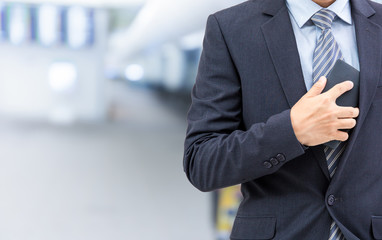 isolated business man hold the smartphone on airport background
