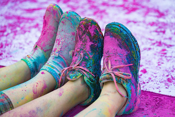 The colorful shoes and legs of teenagers with purple color powder in the public event The Color Run