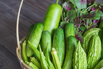 Tropical green organic vegetable on basket on wooden background