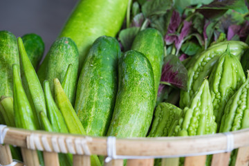 Tropical green organic vegetable on basket on wooden background