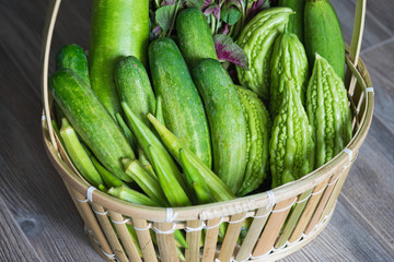 Tropical green organic vegetable on basket on wooden background