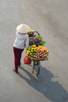 Aerial View Of Asian Vendor With Tropical Fruit Loaded Basket On Bike