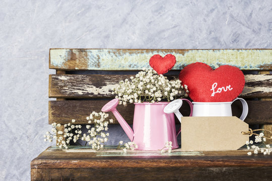 Love concept of blank brown paper tag and red heart and gypsophila in watering can on wood old chair for valentines day and wedding