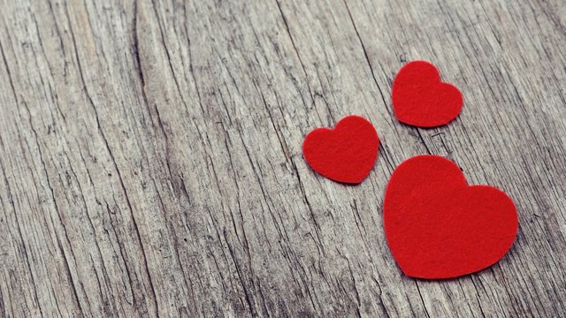 Red hearts on wooden background vintage style