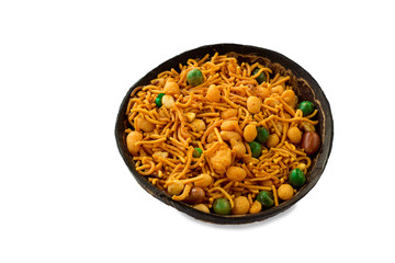 Traditional famous Indian snack namkeeni in coconut shel cup. A mixture of roasted nuts, puffed rice, dried fruits and roasted grams, seasoned with various spices. Light background