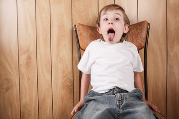 Young boy sitting in a chair with mouth open wide