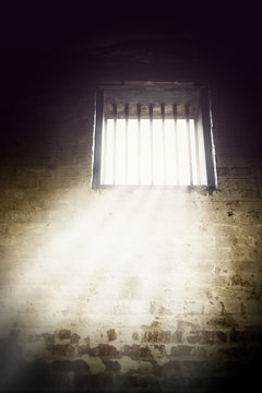 Interior of prison cell with light shining through the window