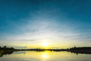 Naklejka na ściany i meble Sunset landscape with blue sky at the calm lake