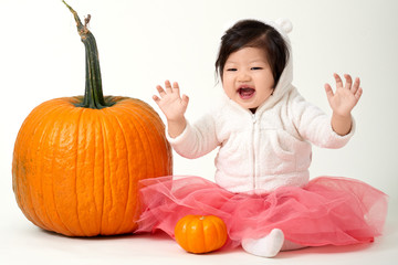 Halloween happy & cute baby girl loves the giant pumpkins