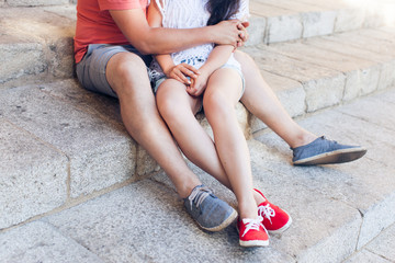 Young couple hugging and sitting on stone steps