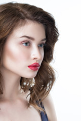 Studio portrait of a beautiful young woman. Fashion Makeup Model with perfect makeup, red lips and smooth, clean skin. Highlighter