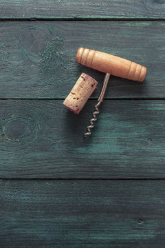 Photo of wine corkscrew and cork on dark background
