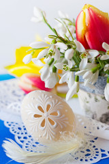Traditional Czech easter decoration - flowerpot with snowdrops flowers and decorated perforated lacy eggs. Spring easter holiday arrangement.