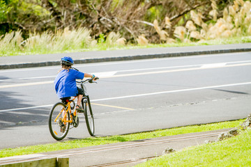 Obraz premium young happy preteen child boy riding a bicycle on urban backgrou