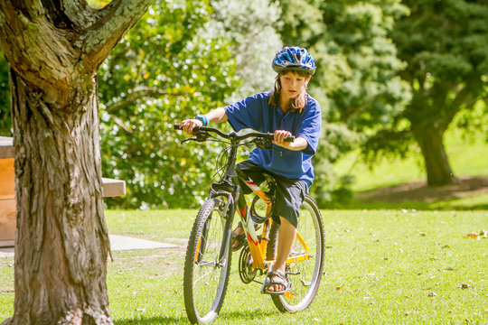 young happy preteen child boy riding a bicycle on natural park b