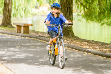 Fototapeta premium young happy preteen child boy riding a bicycle on natural park b