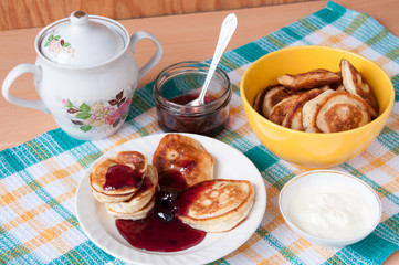 Pancakes for breakfast with cherry jam and sour cream