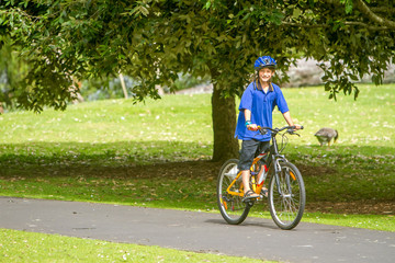 Fototapeta premium young happy preteen child boy riding a bicycle on natural park b