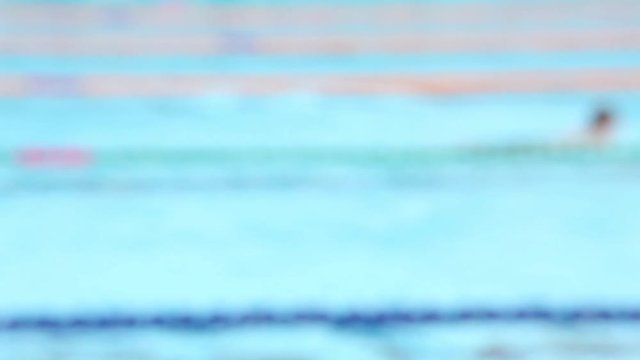 Abstract blurry background of swimming race in outdoor swimming pool.