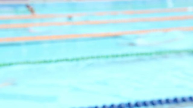 Abstract blurry background of swimming race in outdoor swimming pool.
