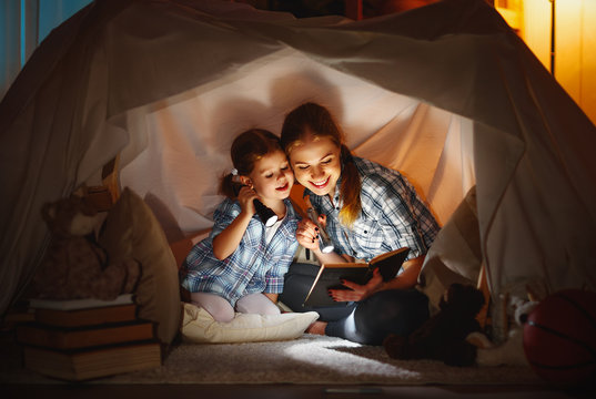 mother and child daughter with a book and a flashlight before go