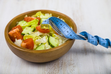 Salad in wooden bowl on a table close-up.