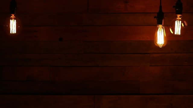   this is a video of old vintage hanging light bulbs against a retro urban Wood pallet background. There's a lot of space for a copy.
