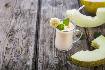 Yogurt and smoothie with melon on a wooden table.