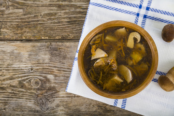 Soup of wild mushrooms on a wooden table