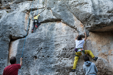 Father and daughter climbing on a limestone wall